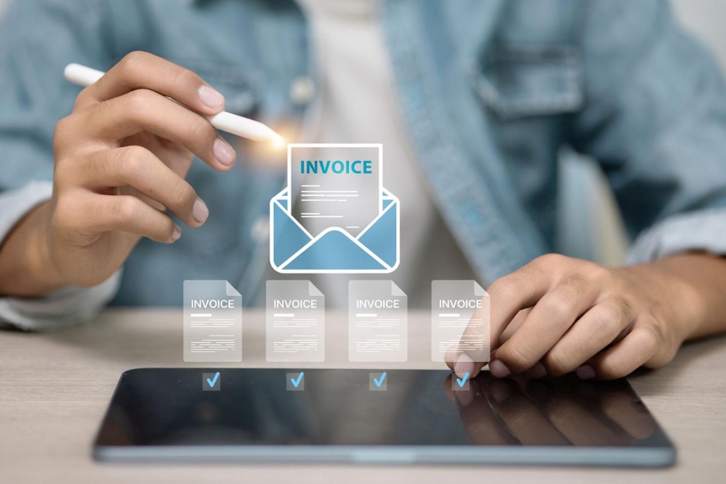 Person reviewing and approving digital invoices on a tablet